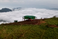 কেওক্রাডংয়ের চূড়া থেকে একটু দূরের একটা কটেজ। চাইলে আপনিও এখানে থাকতে পারেন। কটেজের পিছনে সাদা মেঘ